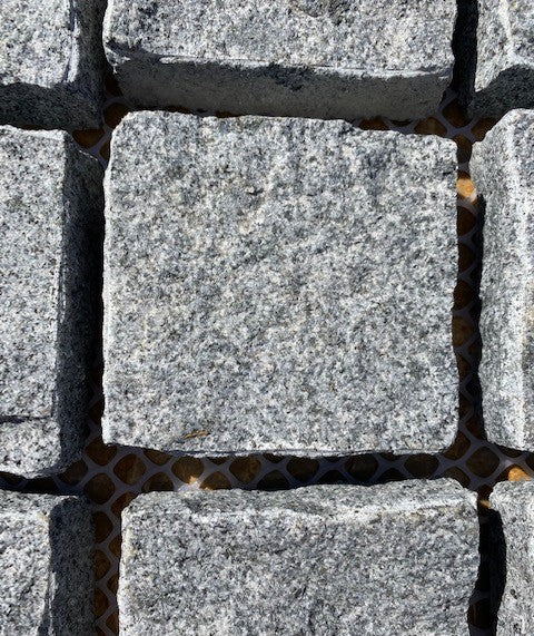 Stormy Granite Cobblestone Pavers - Ideal for driveways, paths and courtyards, these natural surface granite cobbles are non-slip and durable, visit any European city and you will find pavers of a similar material and construction serving their purpose for hundreds of years! Mounted on a plastic mesh for accelerated installation, great for dry or wet setting.