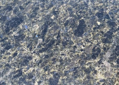 Starry Night - A web of veins glimmers against the deep blue backdrop featuring specks of shimmering opalescent features while providing the durability that granite is known for. The first picture you see is how the stone appears in regular light. The second picture shows how the stone shimmers and reflects it's blue in the light of the sun!